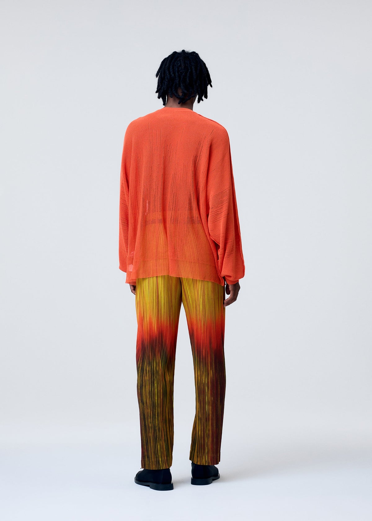 A model wears the HOMME PLISSÉ ISSEY MIYAKE BRUSH CLOSE UP KNIT top.