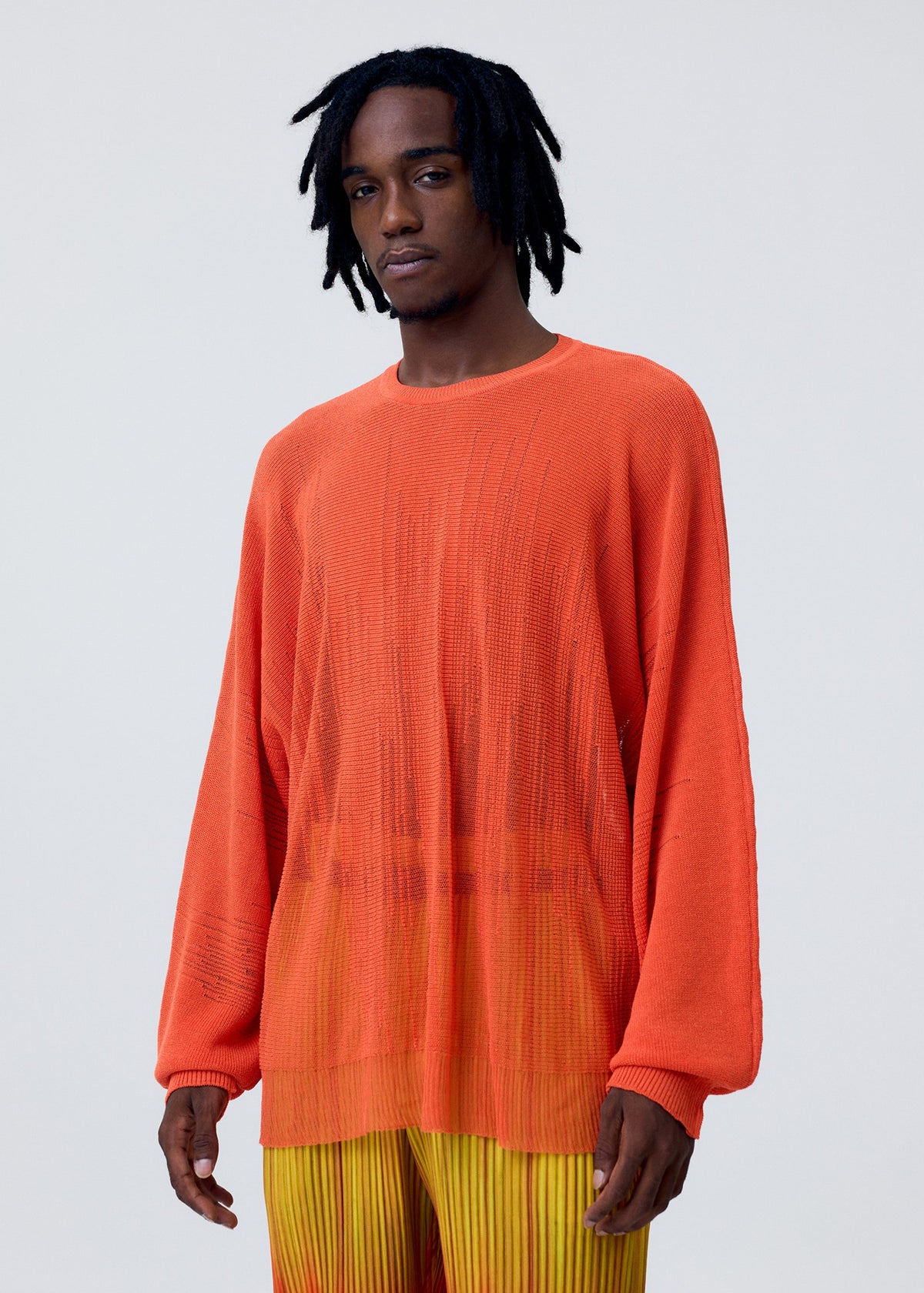 A model wears the HOMME PLISSÉ ISSEY MIYAKE BRUSH CLOSE UP KNIT top.