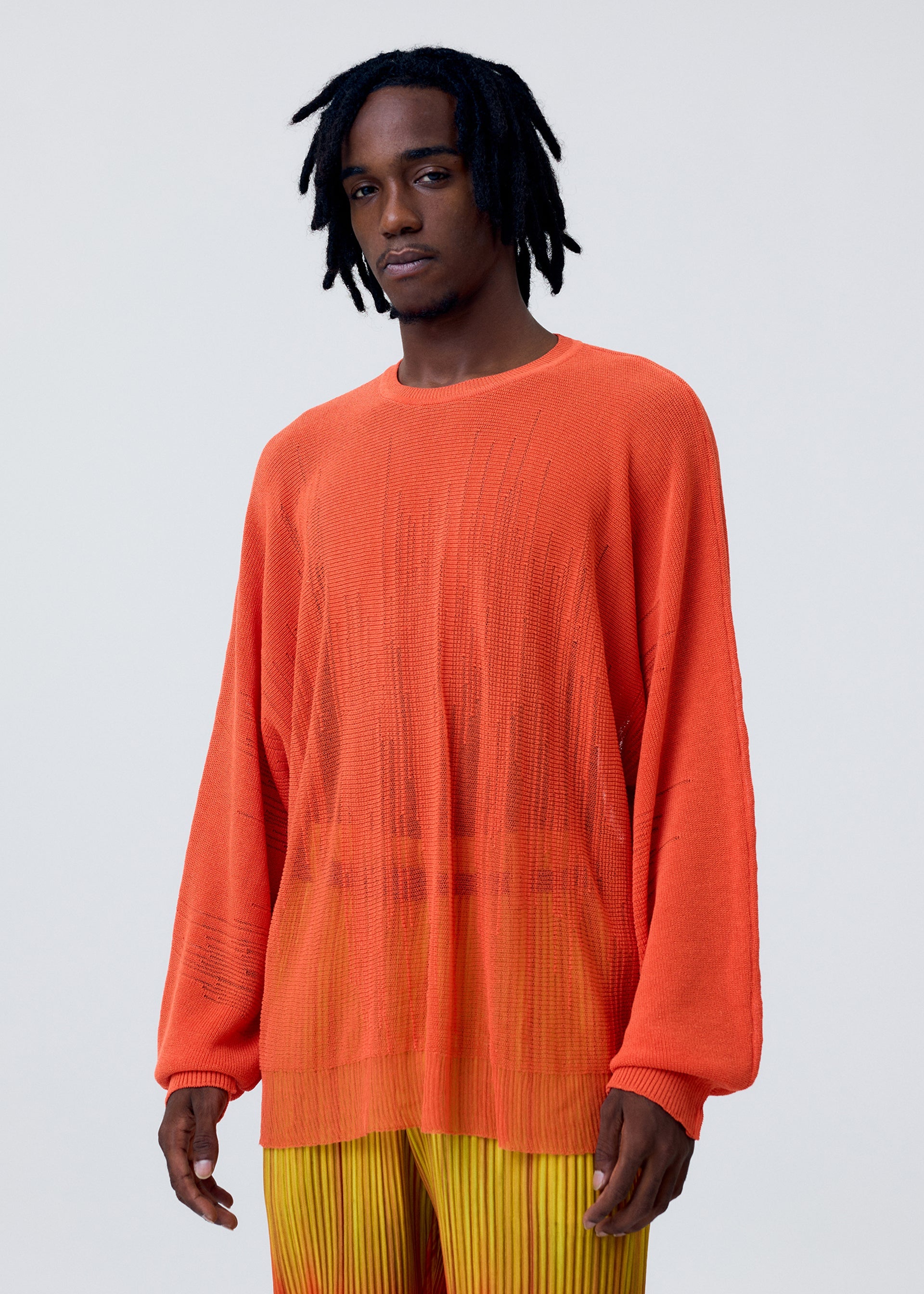 A model wears the HOMME PLISSÉ ISSEY MIYAKE BRUSH CLOSE UP KNIT top.