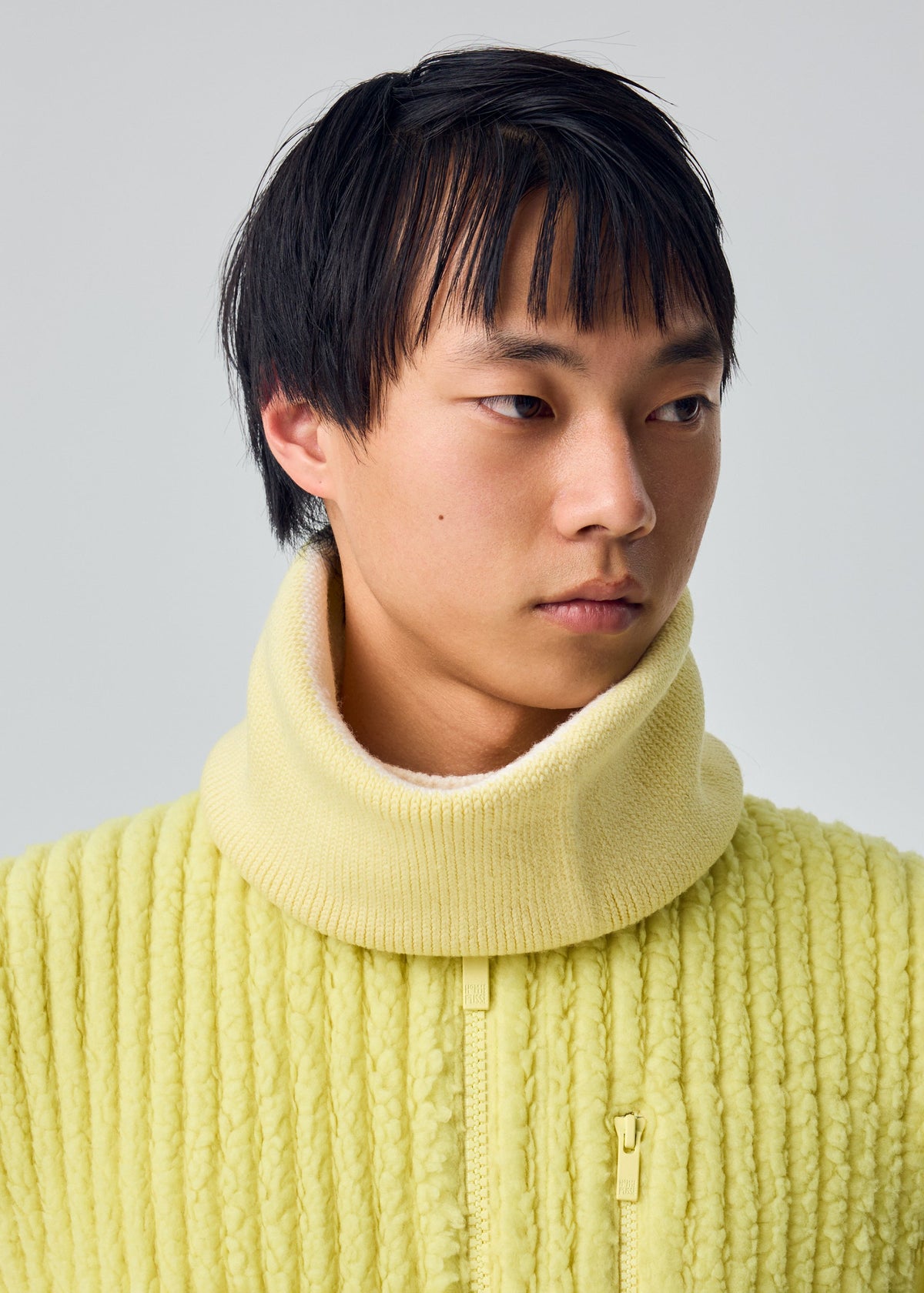 A model wears the HOMME PLISSÉ ISSEY MIYAKE WINTER GEAR : COLOR BLOCK winter-gear-color-block-cap-navy.