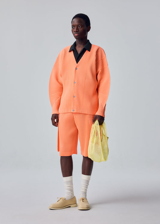 A model wears the HOMME PLISSÉ ISSEY MIYAKE MESH PLEATS BAG mesh-pleats-bag-tote-black.