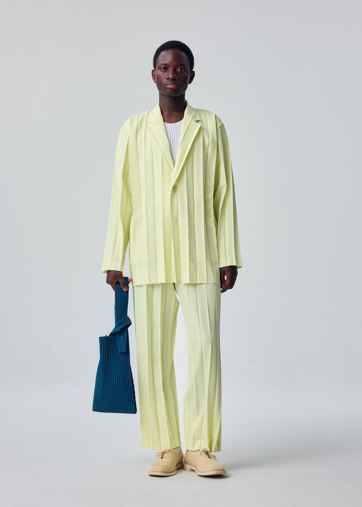 A model wears the HOMME PLISSÉ ISSEY MIYAKE EDGE ENSEMBLE edge-ensemble-trousers-lavender.