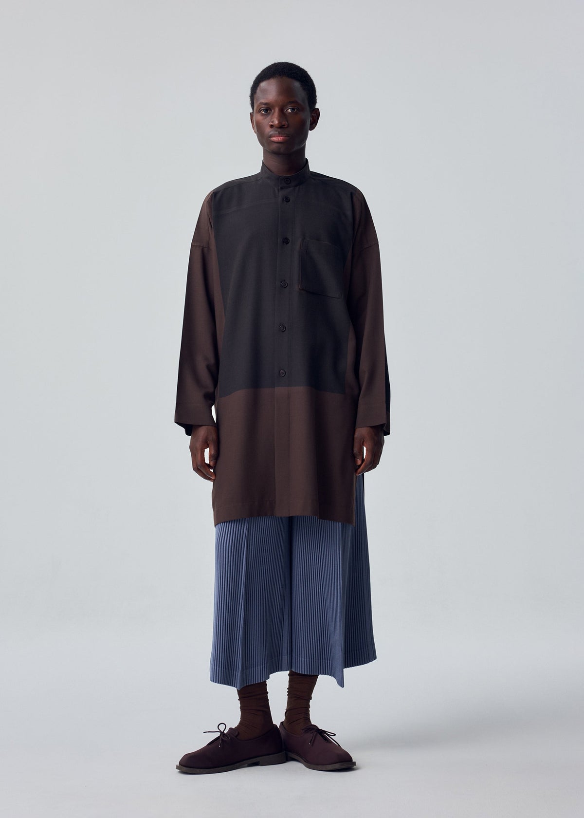 A model wears the HOMME PLISSÉ ISSEY MIYAKE KERSEY PLEATS kersey-pleats-cropped-trousers-purple.