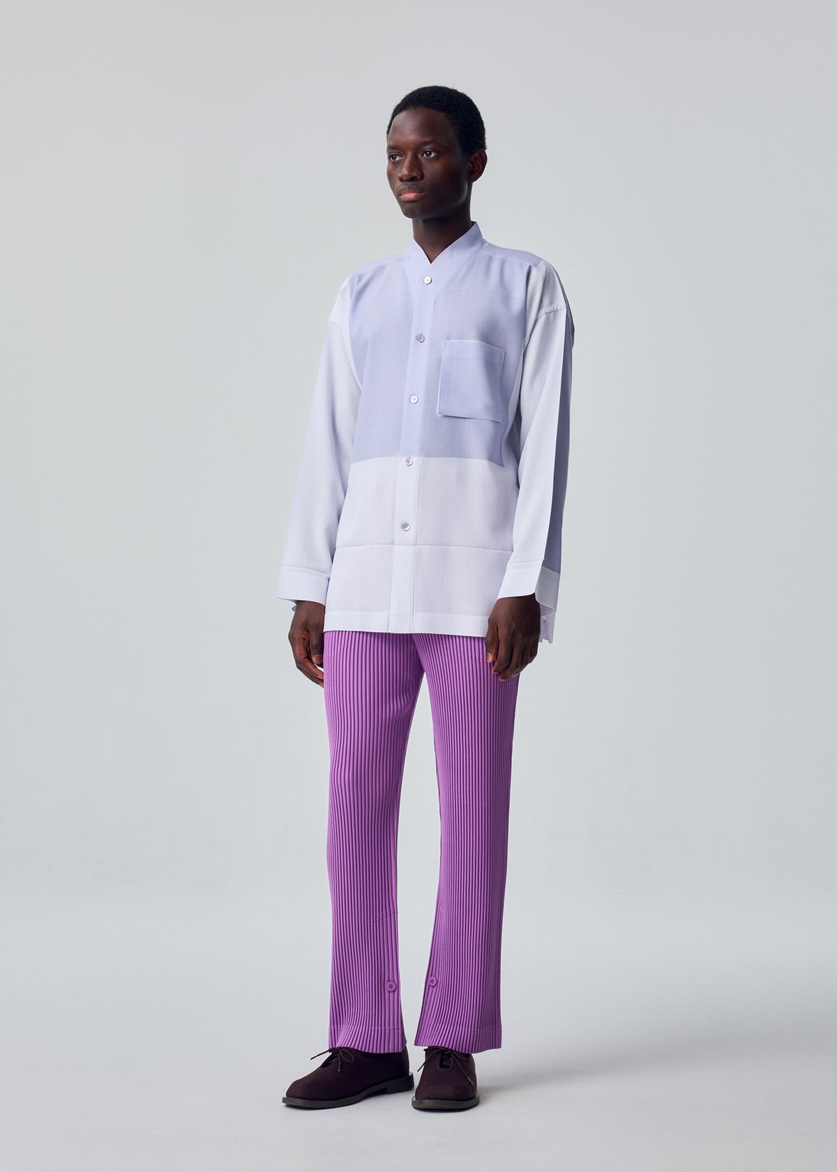A model wears the HOMME PLISSÉ ISSEY MIYAKE KERSEY PLEATS kersey-pleats-classic-cut-trousers-purple.