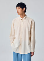 A model wears the HOMME PLISSÉ ISSEY MIYAKE PL RAMIE SHIRT pl-ramie-shirt-origami-collar-shirt-beige.