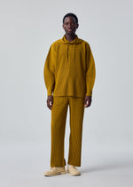 A model wears the HOMME PLISSÉ ISSEY MIYAKE MONTHLY COLORS : OCTOBER monthly-colors-october-classic-cut-trousers-dim-grey.