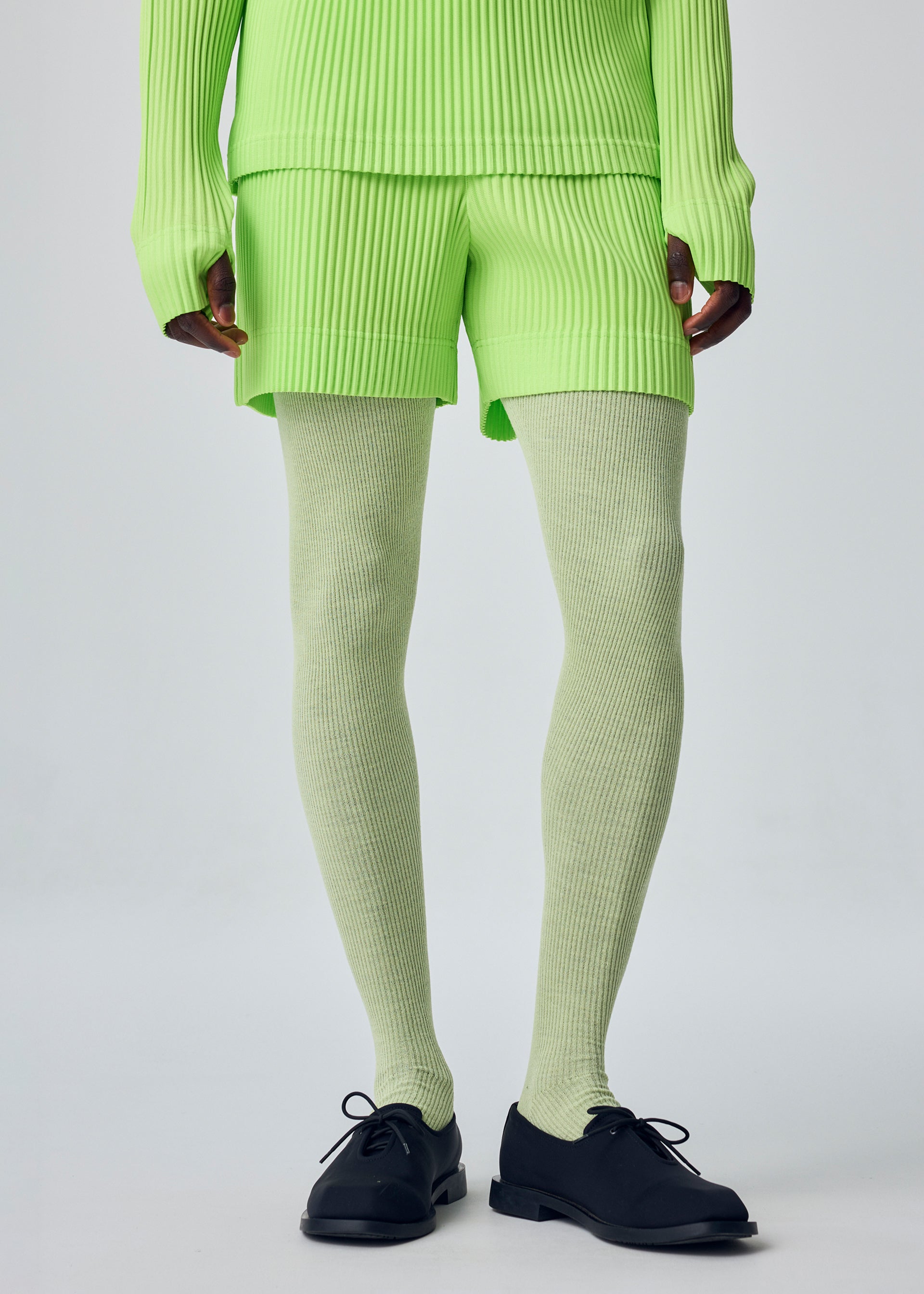 A model wears the HOMME PLISSÉ ISSEY MIYAKE COLOR PLEATS 1 color-pleats-1-shorts-shine-purple.
