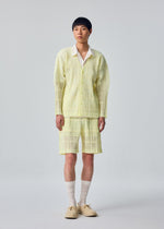 A model wears the HOMME PLISSÉ ISSEY MIYAKE LACE GRID PLEATS lace-grid-pleats-shorts-black.