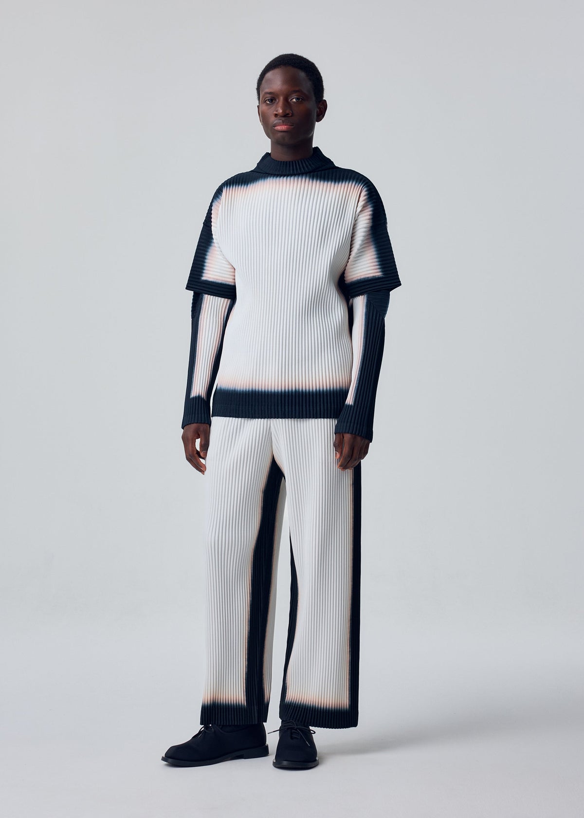 A model wears the HOMME PLISSÉ ISSEY MIYAKE FRAMEWORK : CHUSEN framework-chusen-trousers-black.