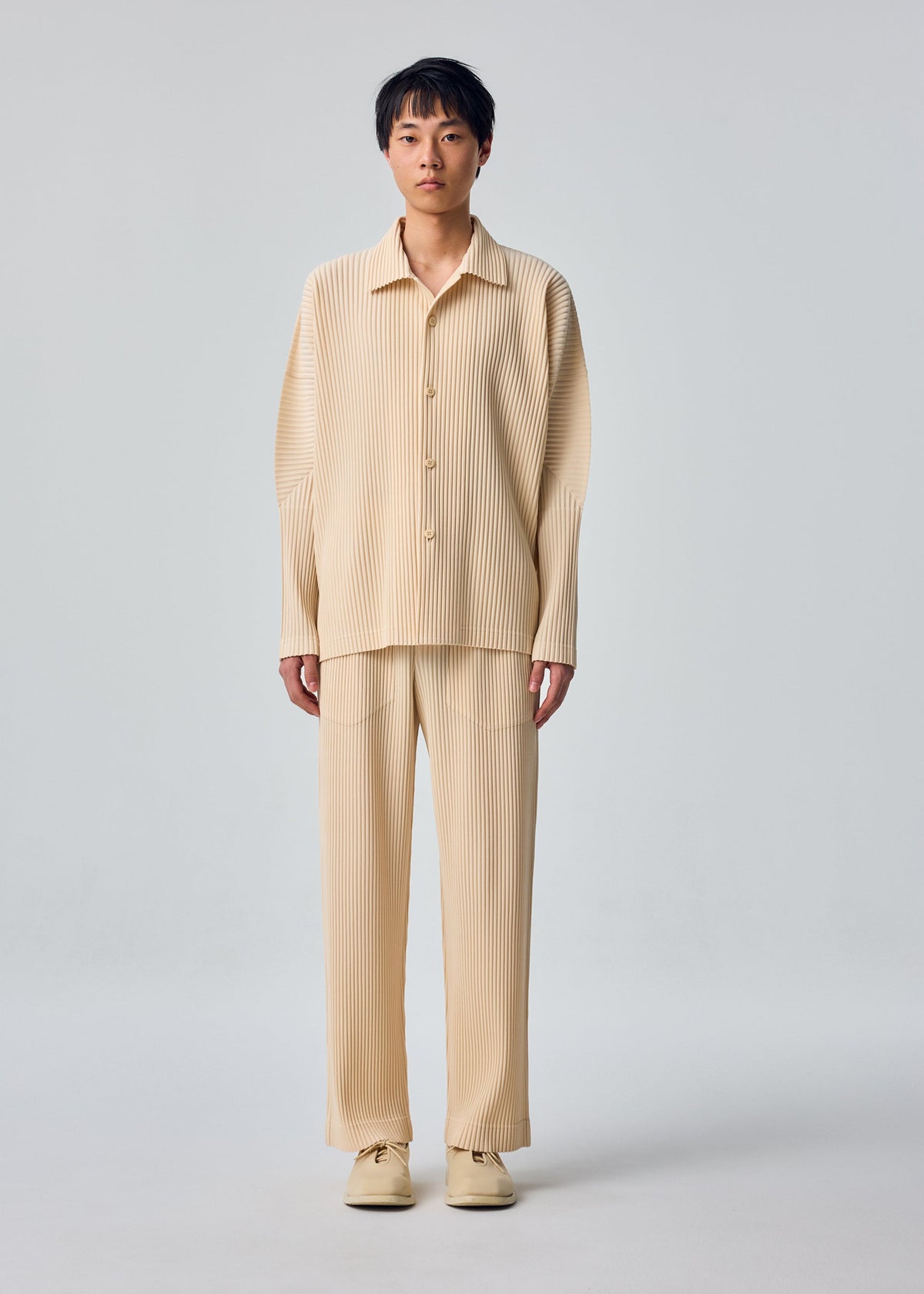 A model wears the HOMME PLISSÉ ISSEY MIYAKE MONTHLY COLORS : OCTOBER monthly-colors-october-long-sleeved-shirt-shade-dandelion.