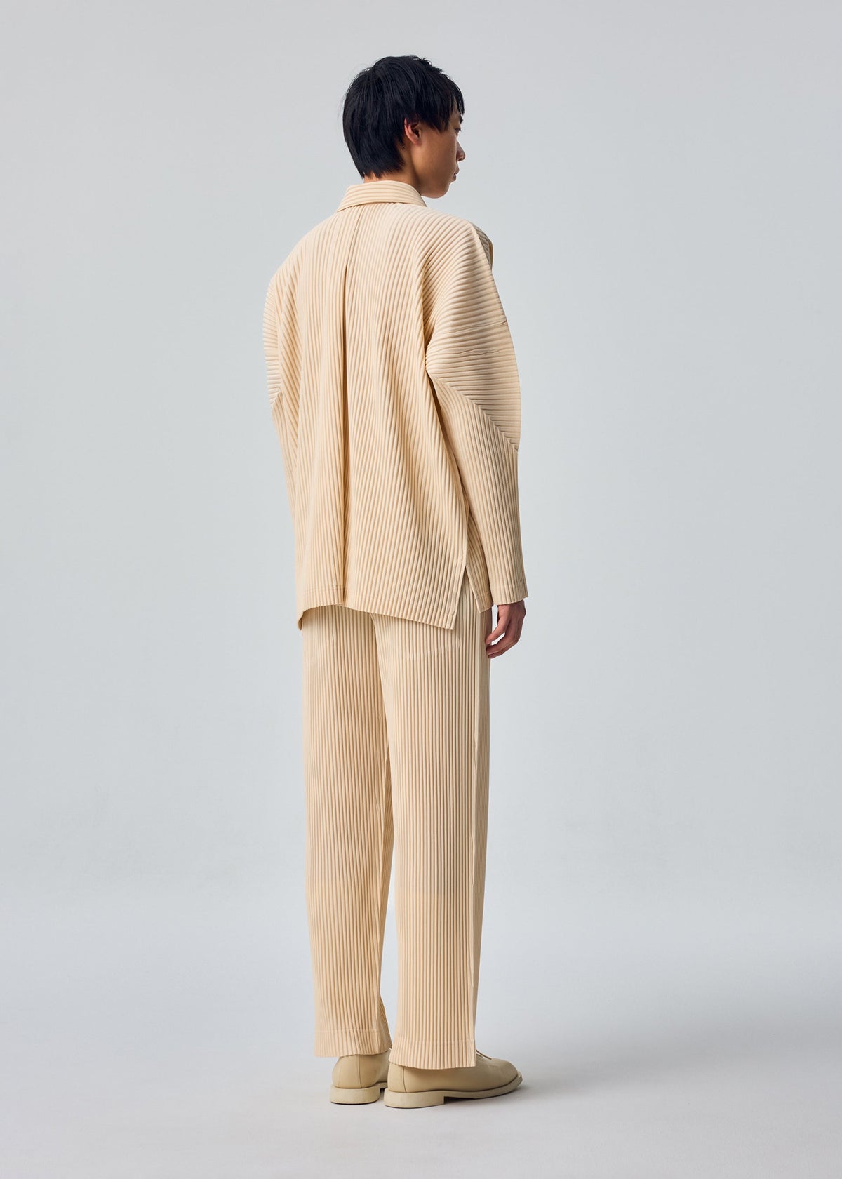 A model wears the HOMME PLISSÉ ISSEY MIYAKE MONTHLY COLORS : OCTOBER monthly-colors-october-long-sleeved-shirt-shade-dandelion.
