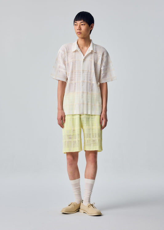 A model wears the HOMME PLISSÉ ISSEY MIYAKE LACE GRID PLEATS lace-grid-pleats-shirt-white.