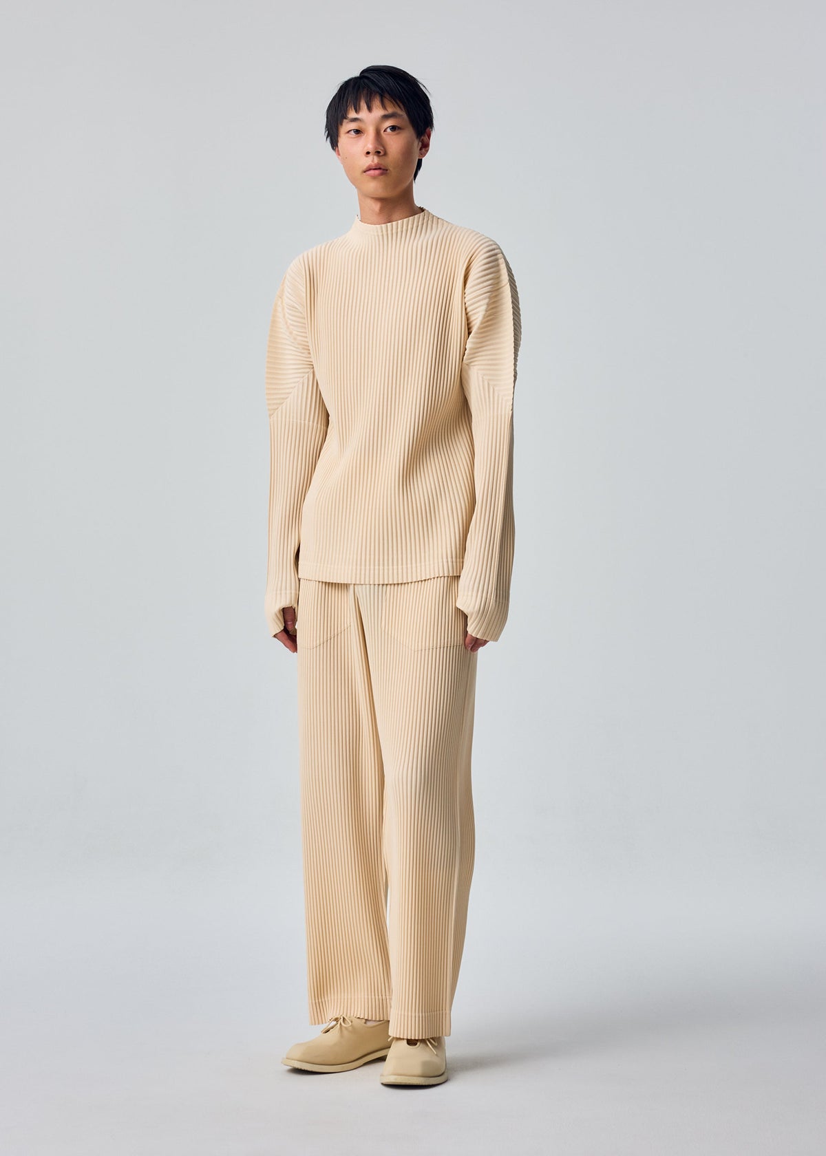 A model wears the HOMME PLISSÉ ISSEY MIYAKE MONTHLY COLORS : OCTOBER monthly-colors-october-long-sleeved-top-dim-grey.