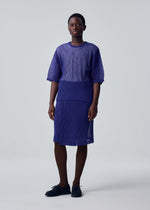 A model wears the HOMME PLISSÉ ISSEY MIYAKE RUSTIC MESH top.