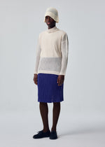A model wears the HOMME PLISSÉ ISSEY MIYAKE RUSTIC MESH top.