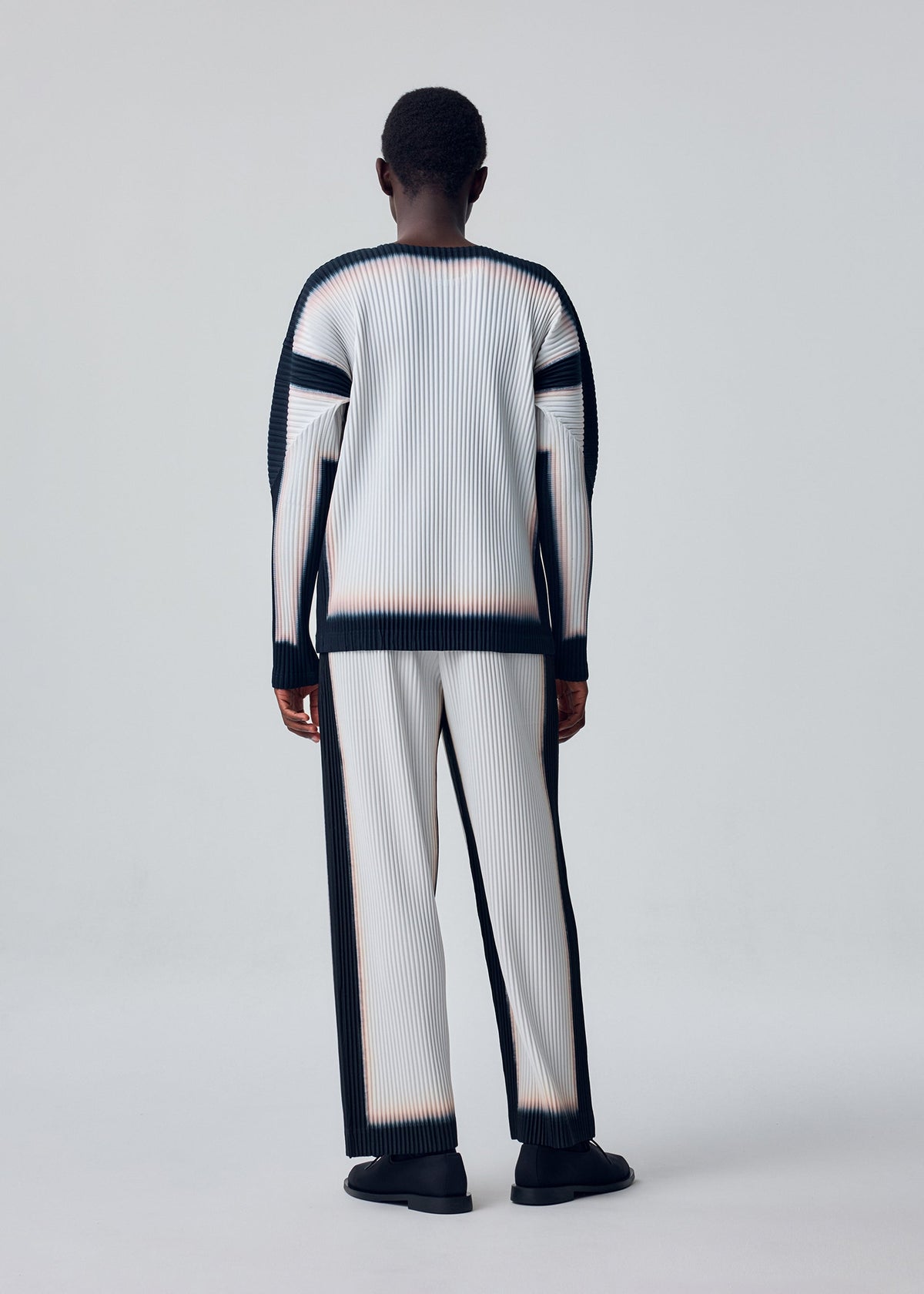 A model wears the HOMME PLISSÉ ISSEY MIYAKE FRAMEWORK : CHUSEN framework-chusen-top-black.