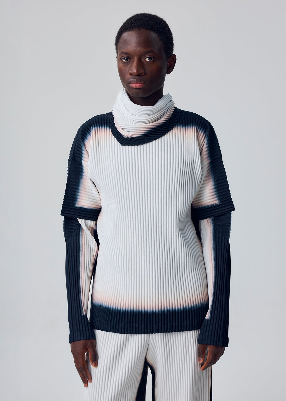 A model wears the HOMME PLISSÉ ISSEY MIYAKE FRAMEWORK : CHUSEN framework-chusen-short-sleeved-top-black.