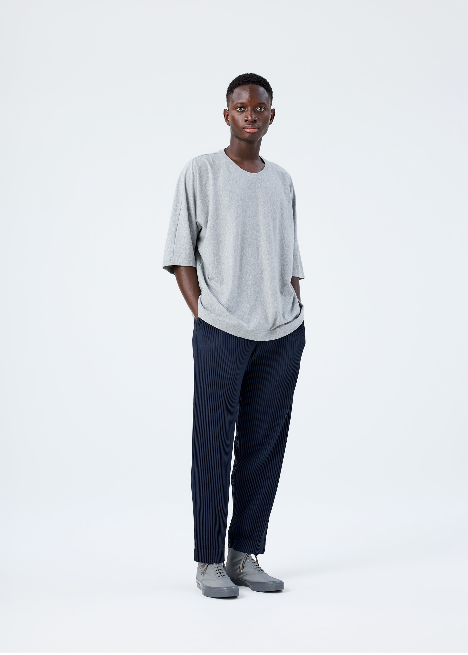 A model wears the HOMME PLISSÉ ISSEY MIYAKE RELEASE-T BASIC top.
