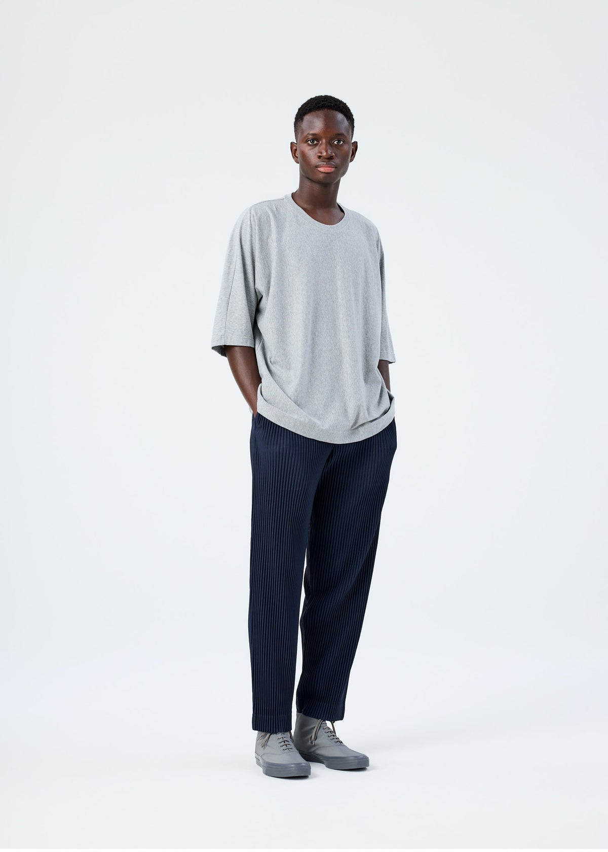 A model wears the HOMME PLISSÉ ISSEY MIYAKE RELEASE-T BASIC top.