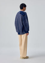 A model wears the HOMME PLISSÉ ISSEY MIYAKE IN THE SHADOW KNIT in-the-shadow-knit-cardigan-blue.