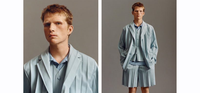 Left: Model wearing EDGE ENSEMBLE Vest and Jacket in Blue, head tilted, looking directly ahead. Set against a dark grey background. Right: Model wearing EDGE ENSEMBLE Vest and Jacket in Blue, hands in pockets, looking straight ahead. Dark grey background.