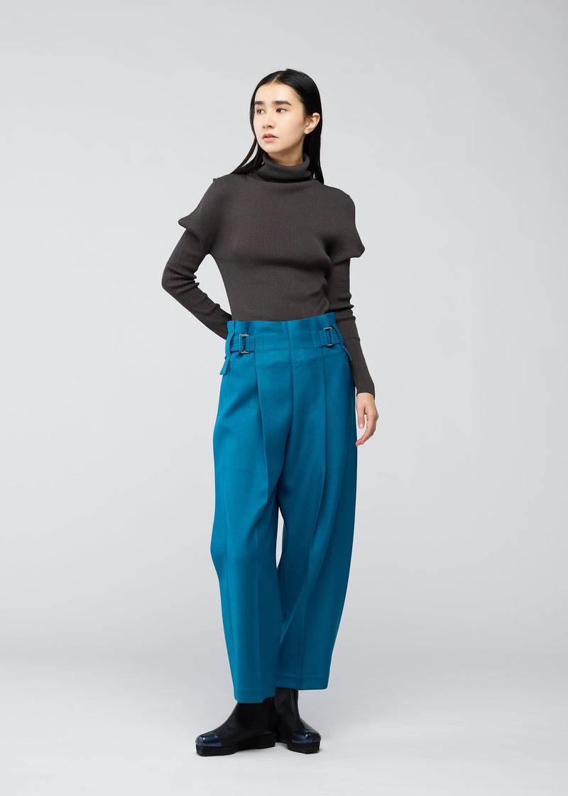 A model wears the 132 5. ISSEY MIYAKE WOOL LIKE FLAT TUCK trousers.