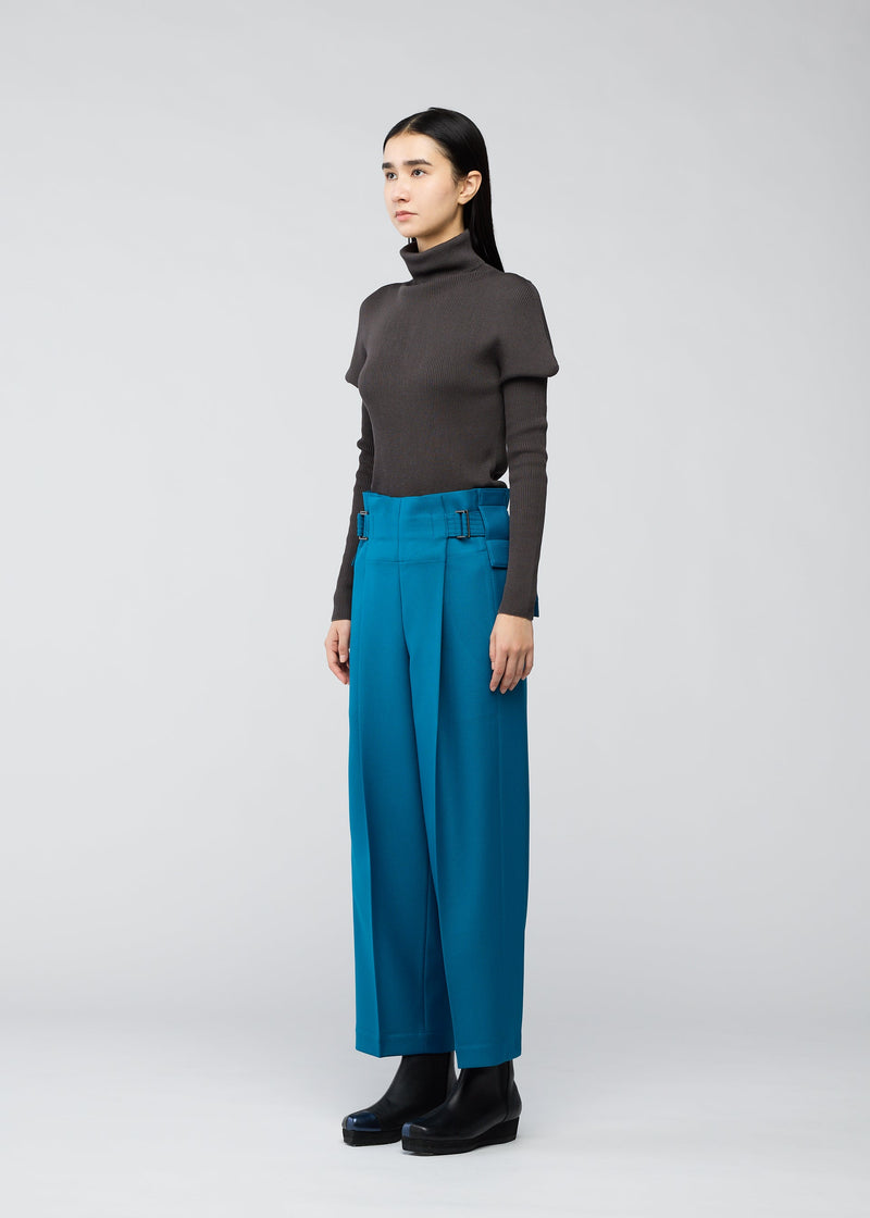 A model wears the 132 5. ISSEY MIYAKE WOOL LIKE FLAT TUCK trousers.