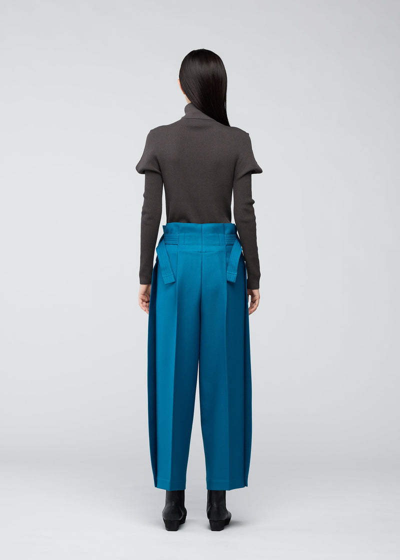 A model wears the 132 5. ISSEY MIYAKE WOOL LIKE FLAT TUCK trousers.