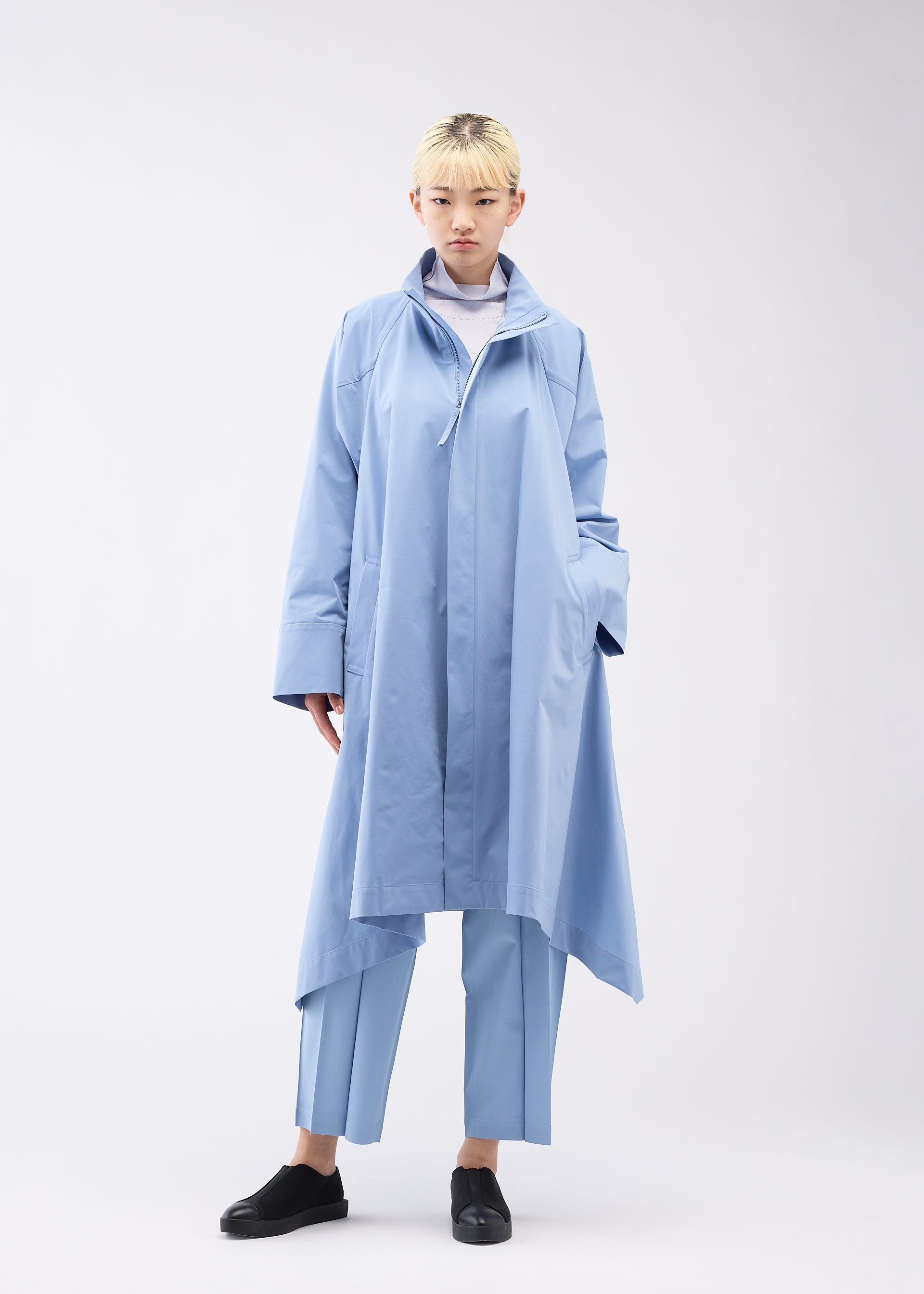 A model wears the 132 5. ISSEY MIYAKE TRAPEZOID COAT coat.