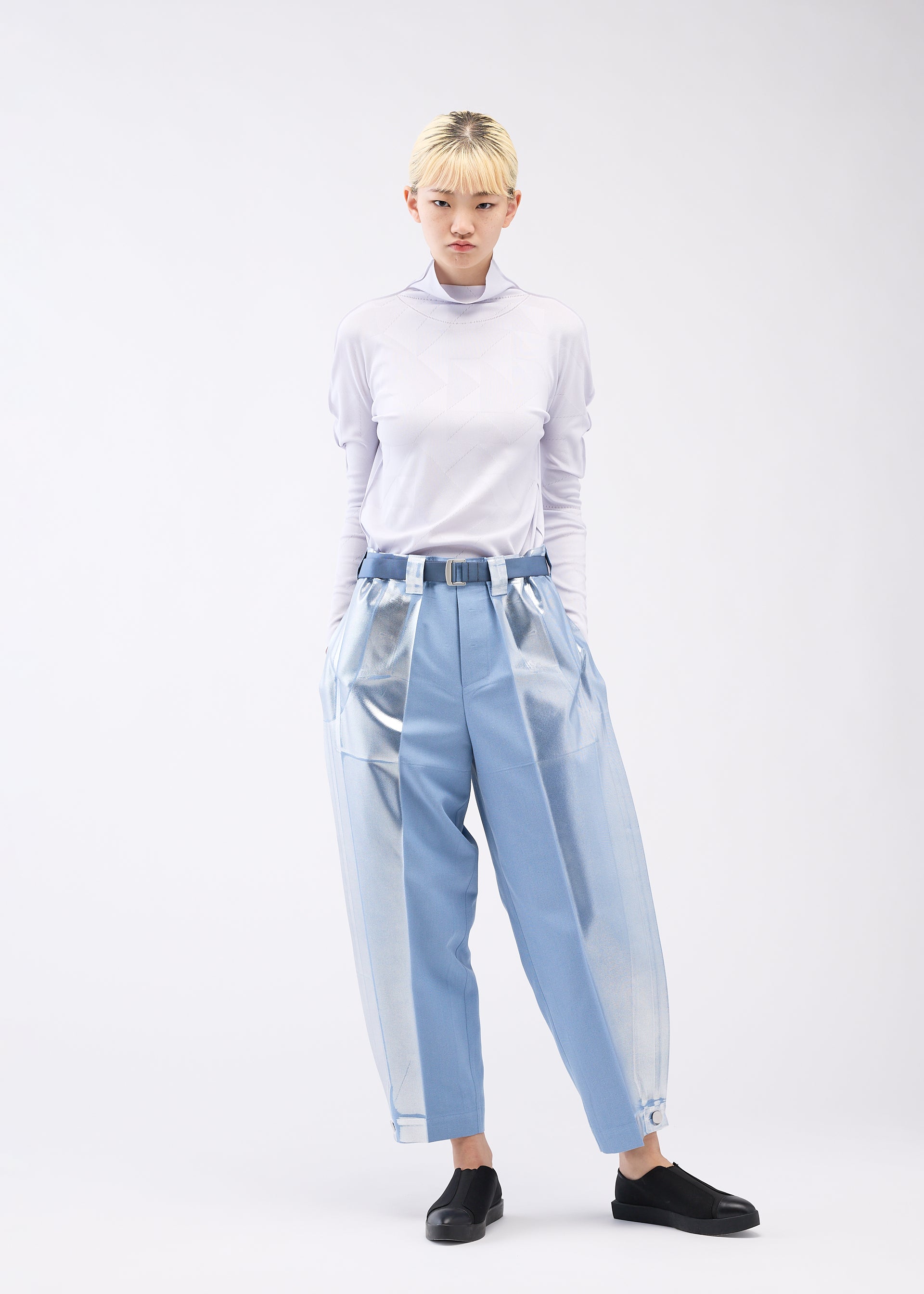 A model wears the 132 5. ISSEY MIYAKE TUCKED FOIL trousers.