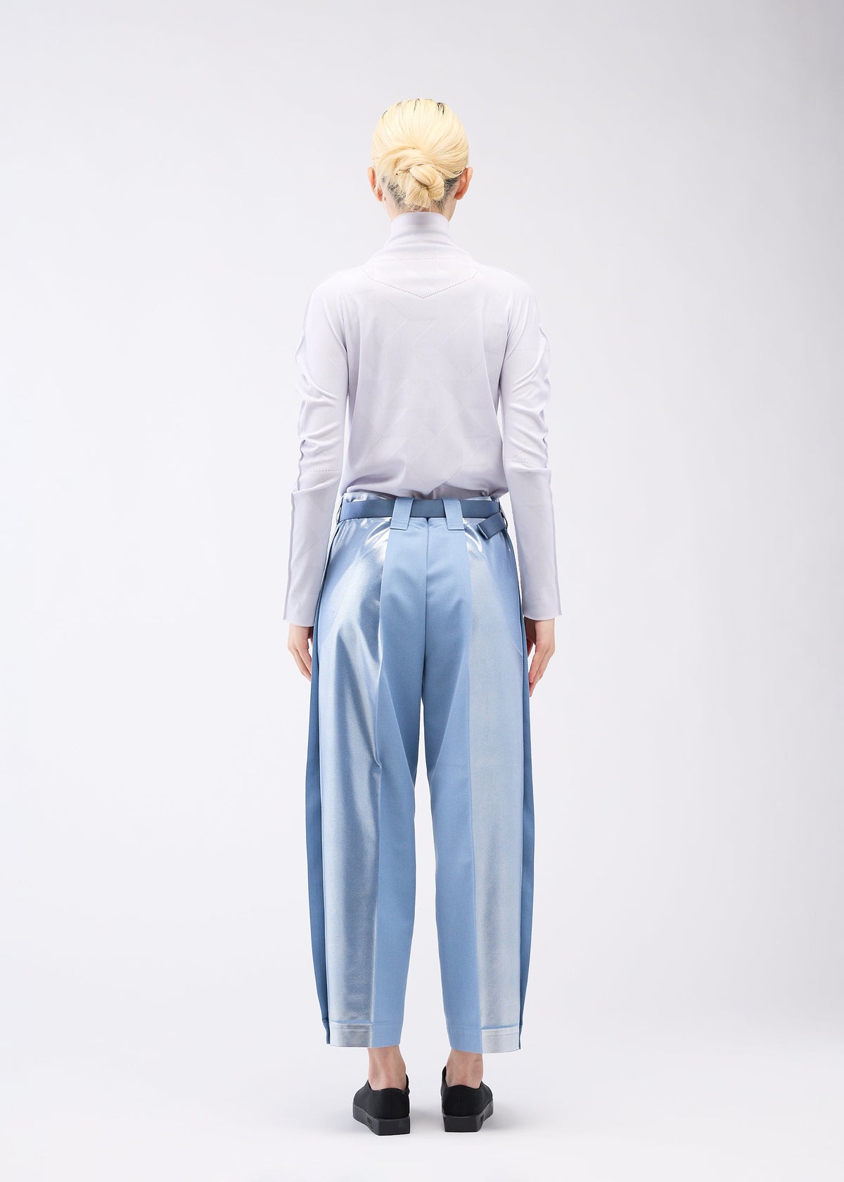 A model wears the 132 5. ISSEY MIYAKE TUCKED FOIL trousers.