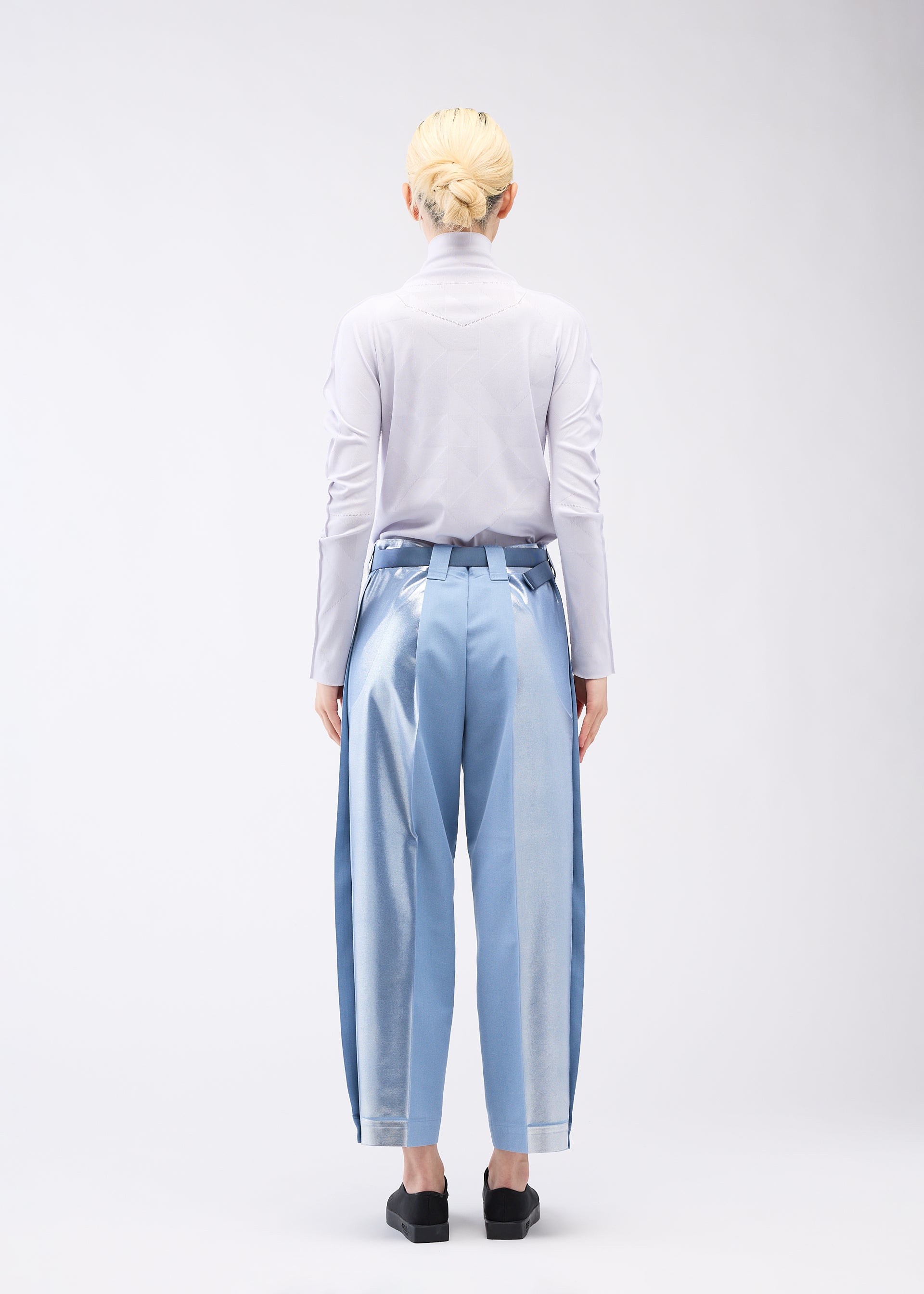 A model wears the 132 5. ISSEY MIYAKE TUCKED FOIL trousers.