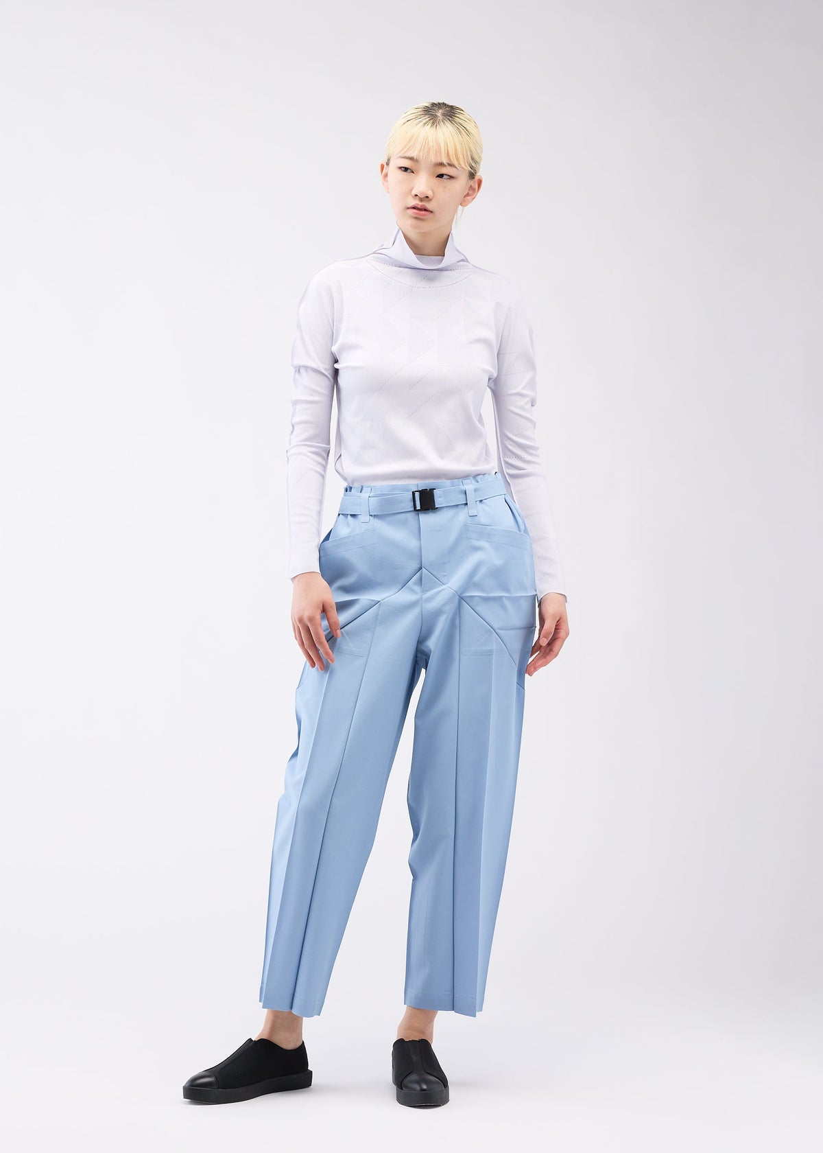 A model wears the 132 5. ISSEY MIYAKE EDGE BOTTOMS trousers.