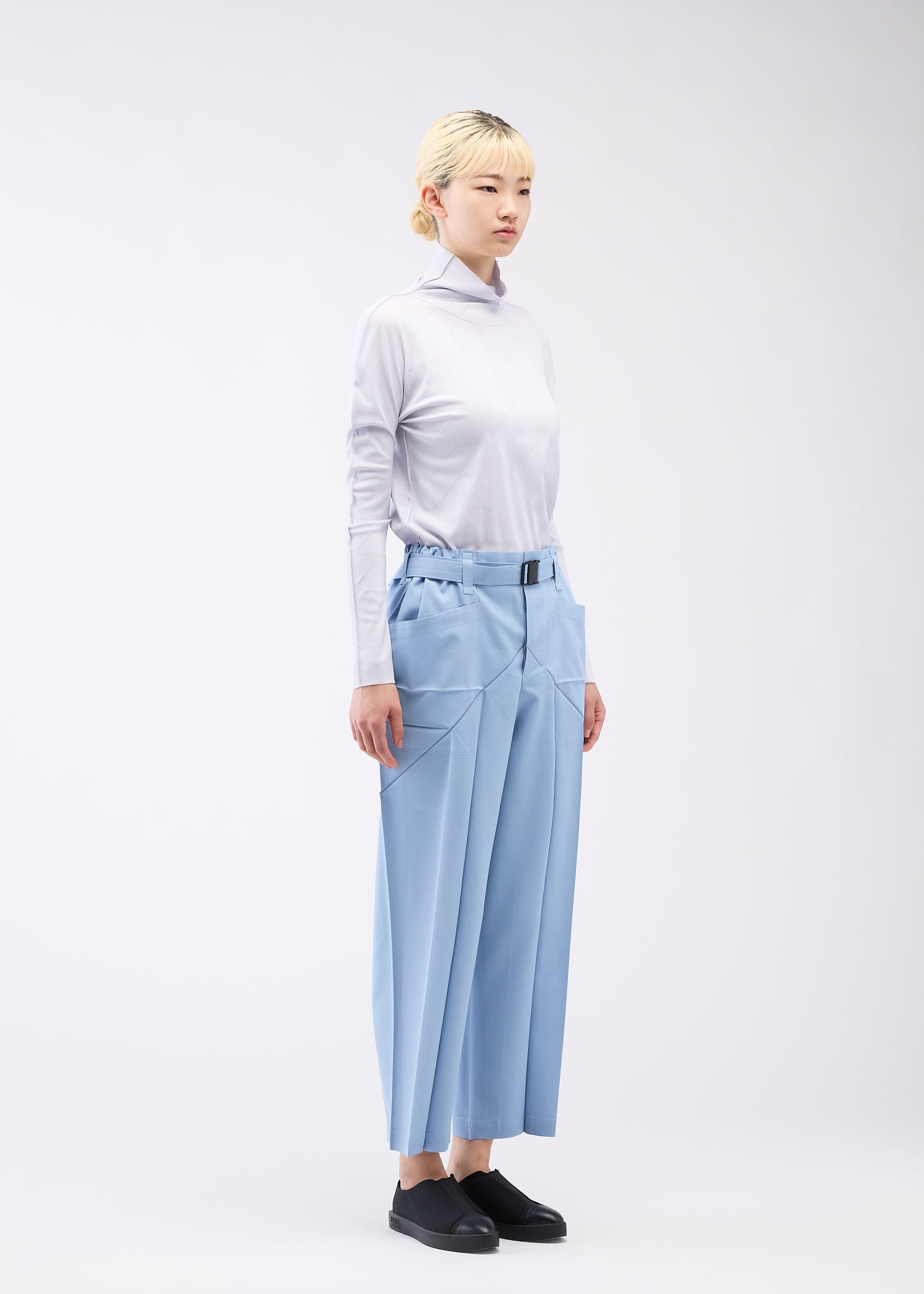 A model wears the 132 5. ISSEY MIYAKE EDGE BOTTOMS trousers.