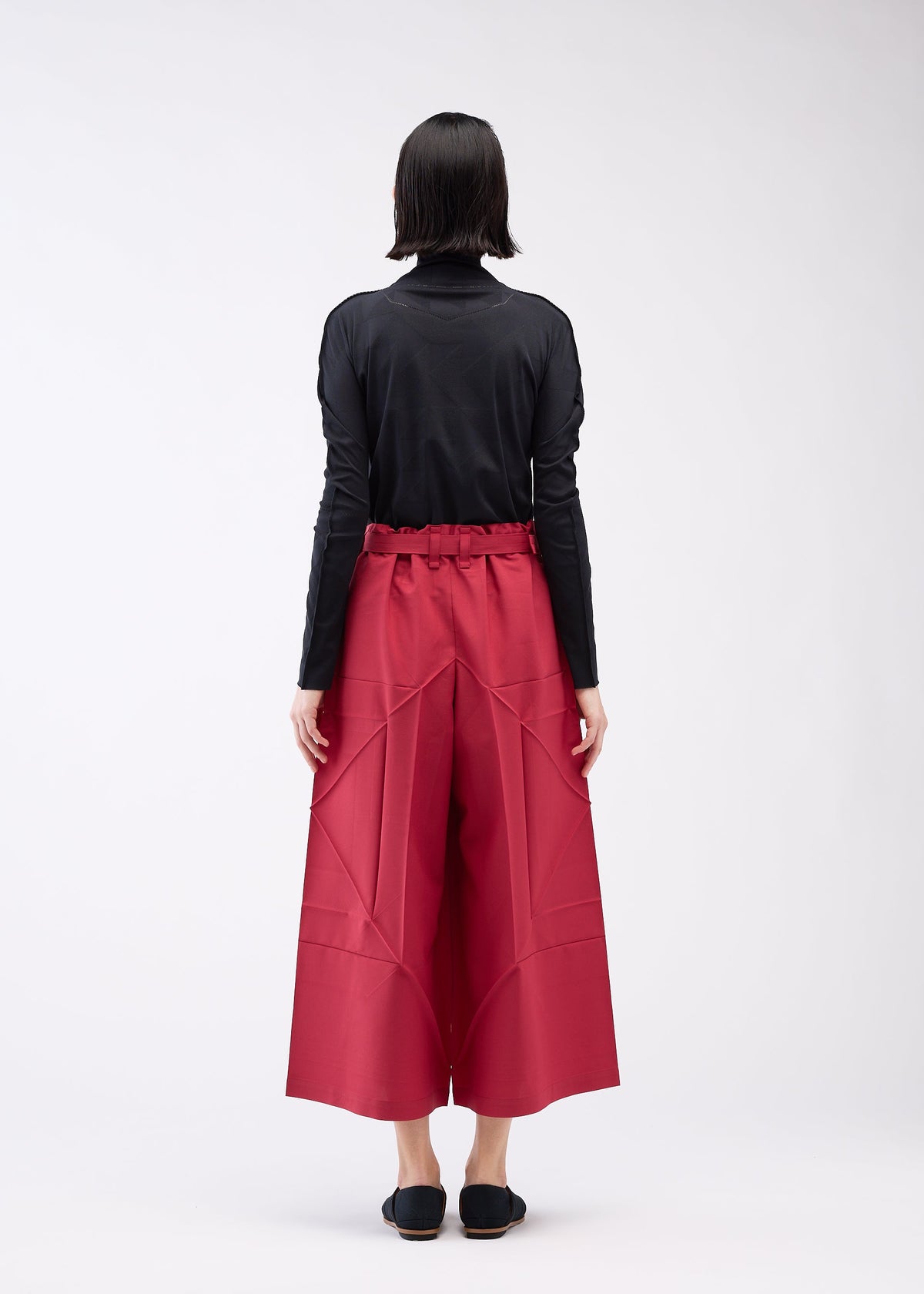 A model wears the 132 5. ISSEY MIYAKE EDGE BOTTOMS trousers.