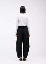 A model wears the 132 5. ISSEY MIYAKE PARALLEL WRAP trousers.