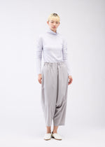 A model wears the 132 5. ISSEY MIYAKE SEAMLESS 1 trousers.