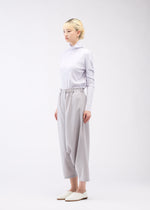 A model wears the 132 5. ISSEY MIYAKE SEAMLESS 1 trousers.