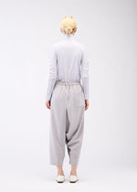 A model wears the 132 5. ISSEY MIYAKE SEAMLESS 1 trousers.