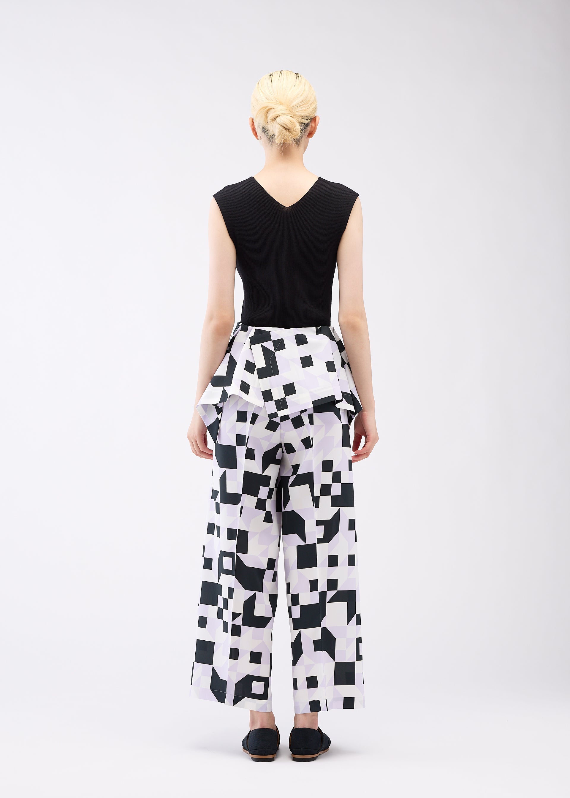 A model wears the 132 5. ISSEY MIYAKE BOX COMPOSITION trousers.