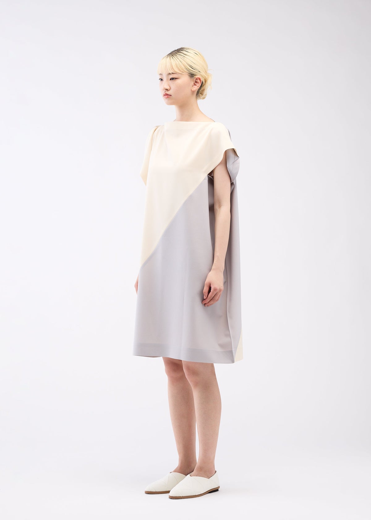 A model wears the 132 5. ISSEY MIYAKE FLAT T BI COLOR dress.