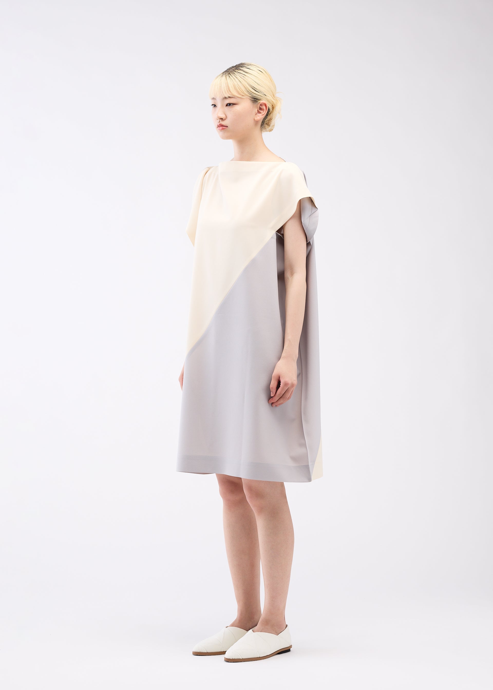 A model wears the 132 5. ISSEY MIYAKE FLAT T BI COLOR dress.
