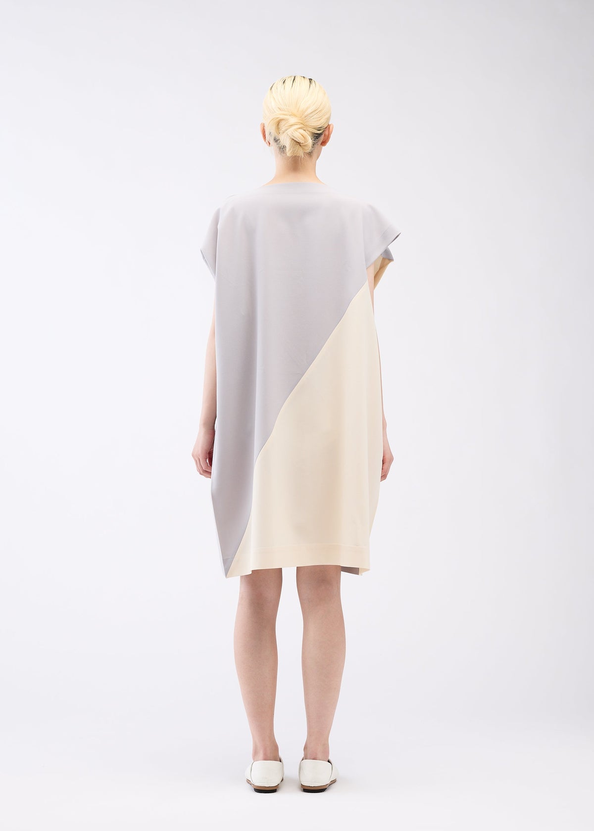 A model wears the 132 5. ISSEY MIYAKE FLAT T BI COLOR dress.