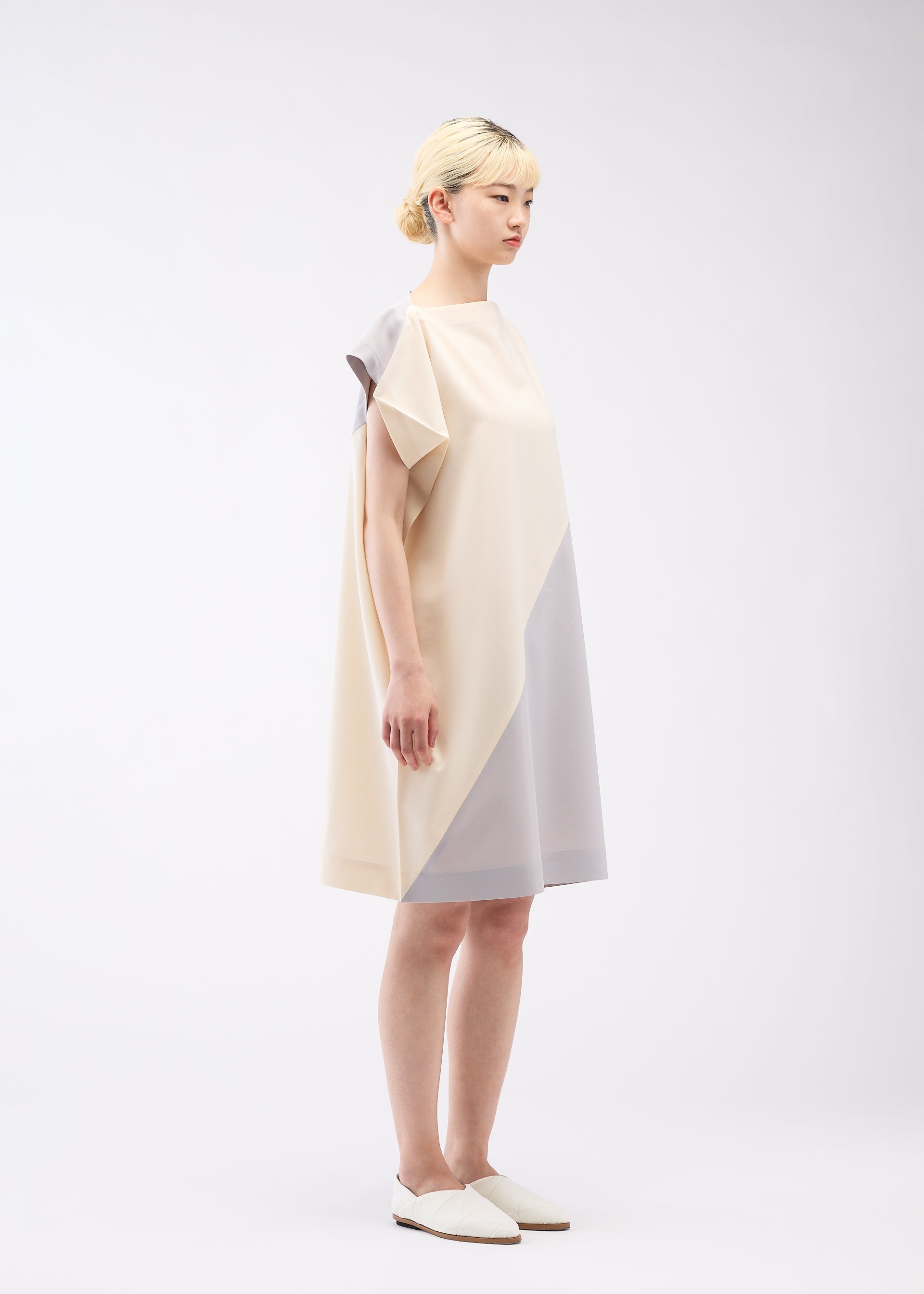 A model wears the 132 5. ISSEY MIYAKE FLAT T BI COLOR dress.
