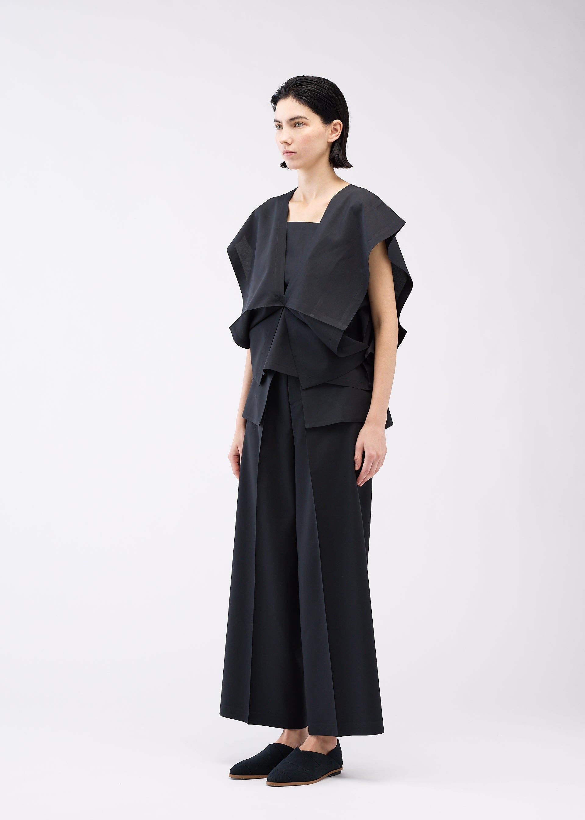 A model wears the 132 5. ISSEY MIYAKE BOX COMPOSITION SOLID shirt.