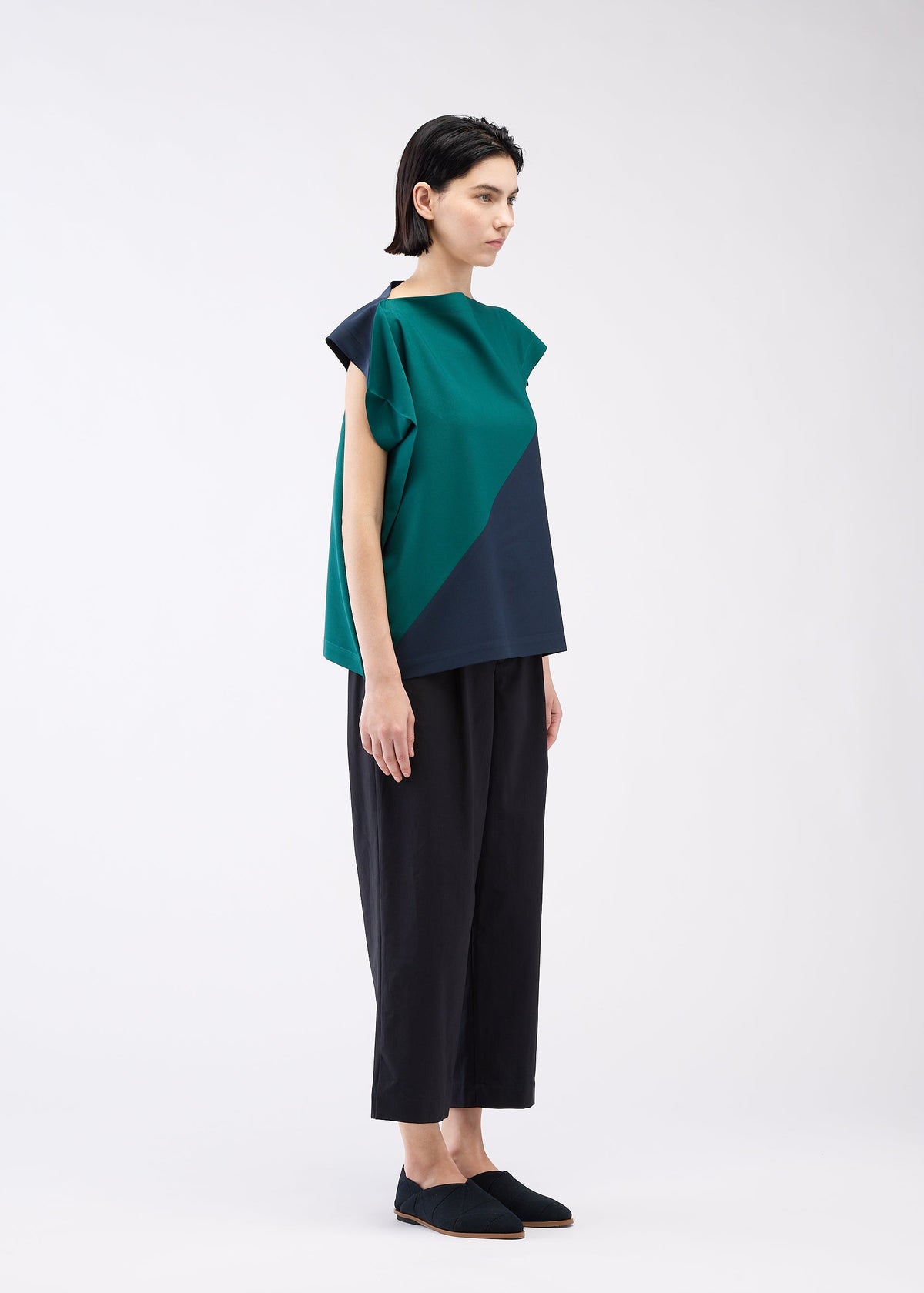 A model wears the 132 5. ISSEY MIYAKE FLAT T BI COLOR shirt.
