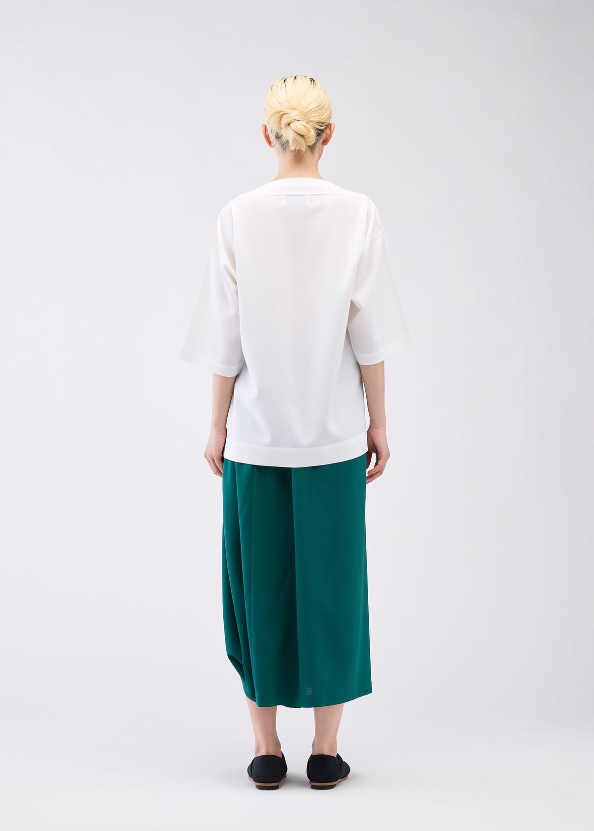 A model wears the 132 5. ISSEY MIYAKE FLAT ONE TUCK T shirt.