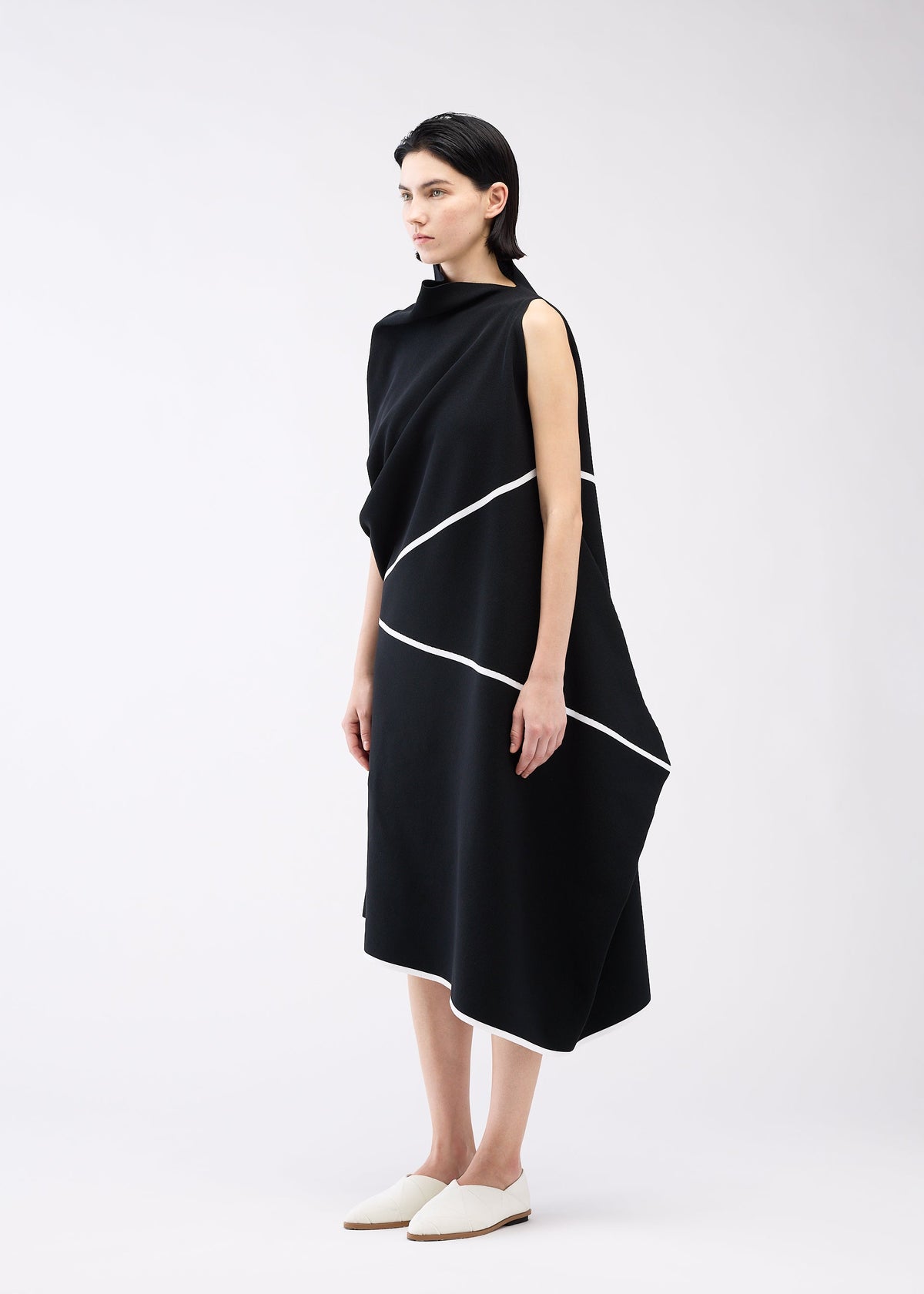 A model wears the 132 5. ISSEY MIYAKE HALF CUBE PATTERN KNIT dress.
