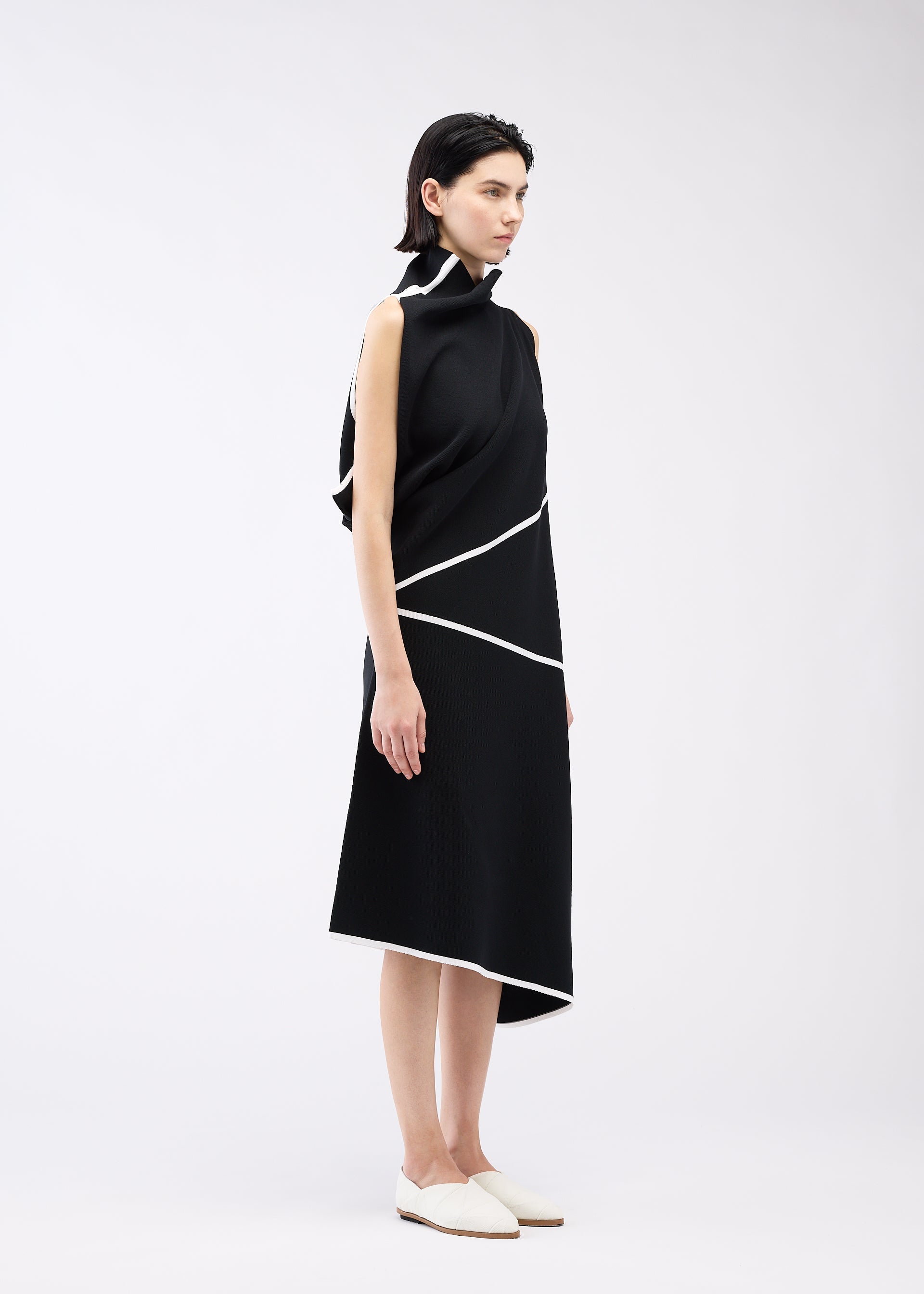 A model wears the 132 5. ISSEY MIYAKE HALF CUBE PATTERN KNIT dress.