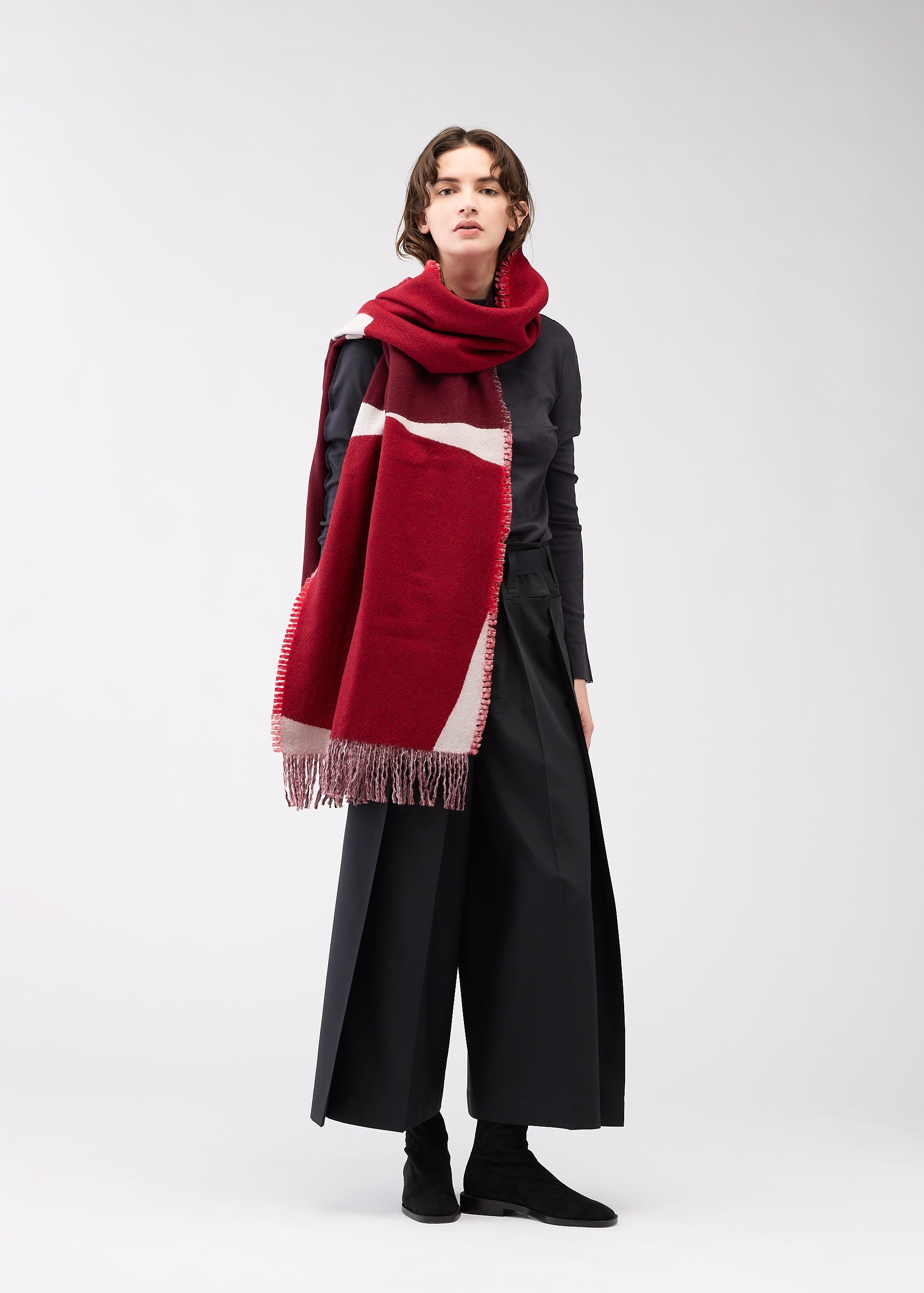 A model wears the 132 5. ISSEY MIYAKE POSITIONS STOLE stole.